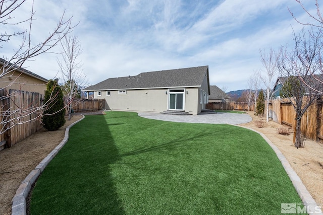 view of yard featuring a fenced backyard, entry steps, and a patio