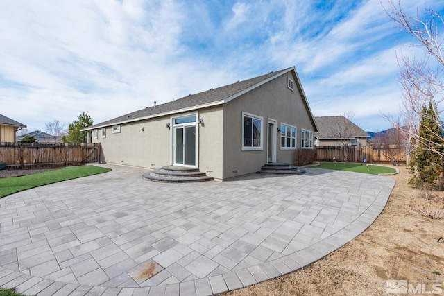 back of property featuring a fenced backyard, stucco siding, entry steps, and a patio