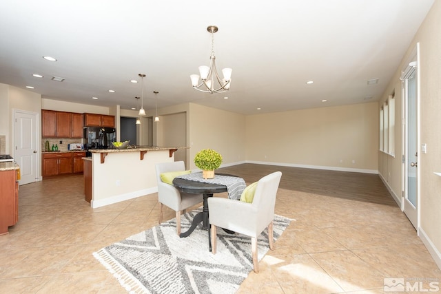 dining space with recessed lighting, baseboards, a notable chandelier, and light tile patterned floors