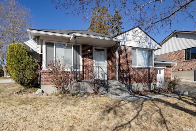 view of front of home featuring brick siding and a front yard