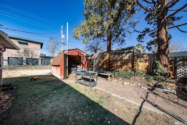 view of yard featuring an outbuilding, fence private yard, and a storage shed