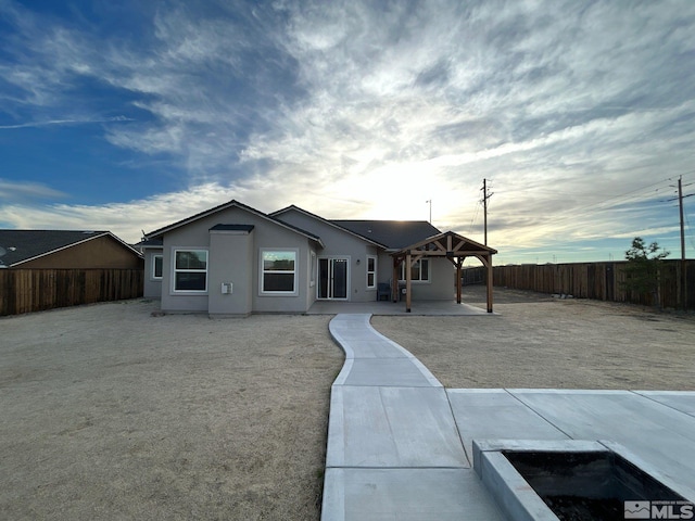 view of front of home featuring a gazebo, a patio area, a fenced backyard, and stucco siding