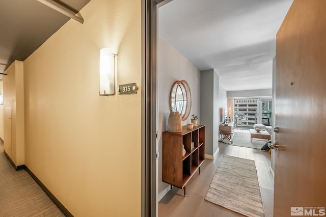 hall with wood finished floors and baseboards