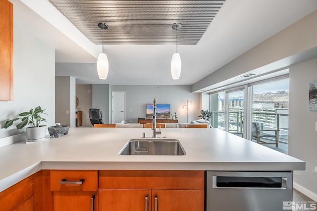 kitchen with dishwasher, light countertops, open floor plan, and a sink