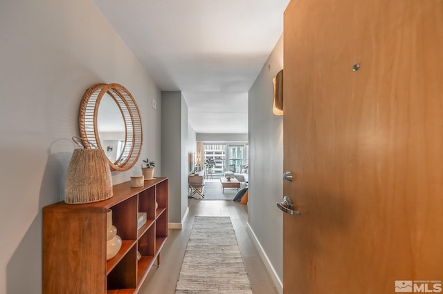 hall featuring baseboards and wood finished floors