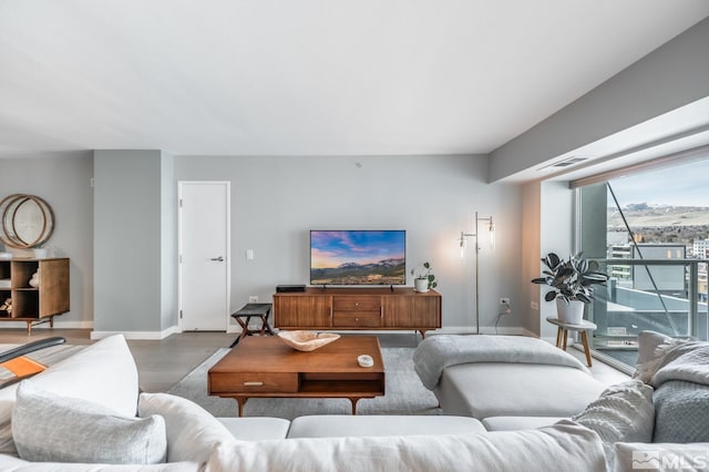 living room featuring wood finished floors, visible vents, and baseboards