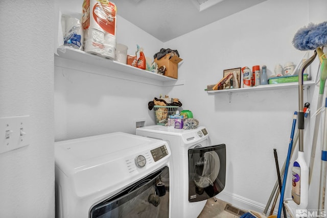 laundry area with laundry area, visible vents, and washing machine and clothes dryer