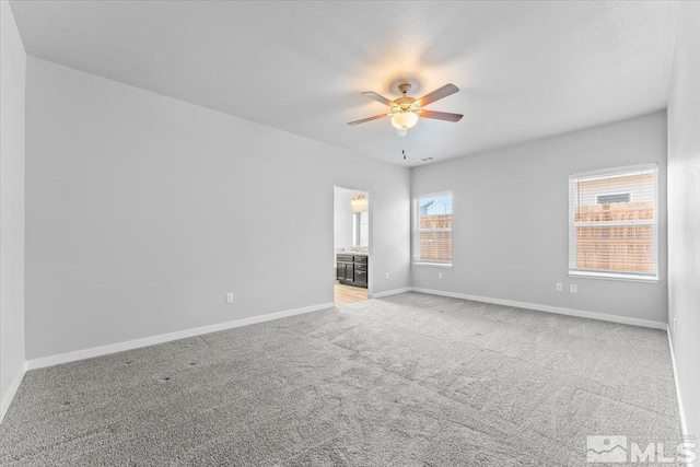 unfurnished room featuring carpet, a ceiling fan, and baseboards