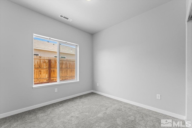 carpeted spare room featuring visible vents and baseboards