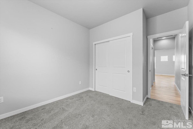 unfurnished bedroom with a closet, baseboards, and carpet floors