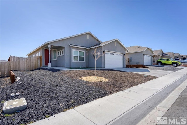 ranch-style house with stucco siding, an attached garage, driveway, and fence