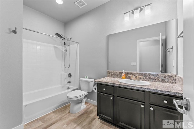 full bathroom with visible vents, toilet, wood finished floors, shower / bathing tub combination, and vanity