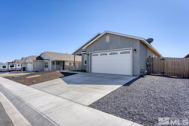 single story home featuring stucco siding, an attached garage, driveway, and fence