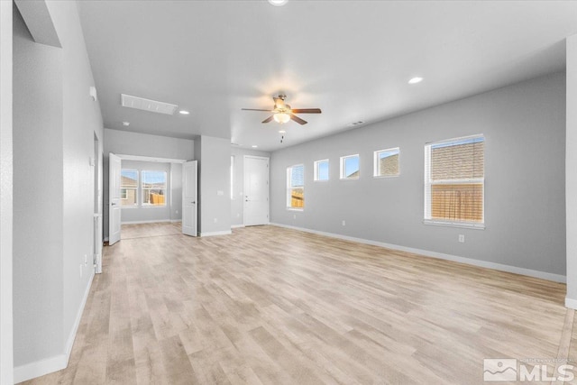 empty room with light wood-type flooring, baseboards, a healthy amount of sunlight, and ceiling fan