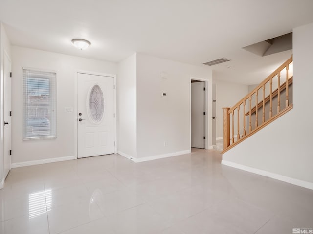 entrance foyer with stairs, light tile patterned floors, visible vents, and baseboards