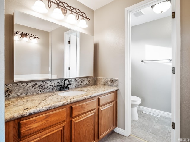 bathroom with visible vents, baseboards, toilet, and vanity