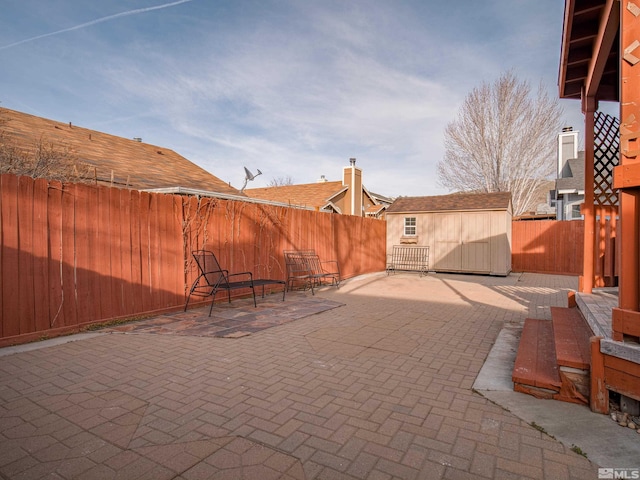 view of patio / terrace with a storage shed, an outdoor structure, and a fenced backyard