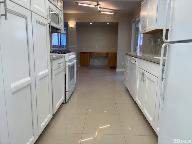 kitchen featuring light tile patterned floors, white appliances, and white cabinetry