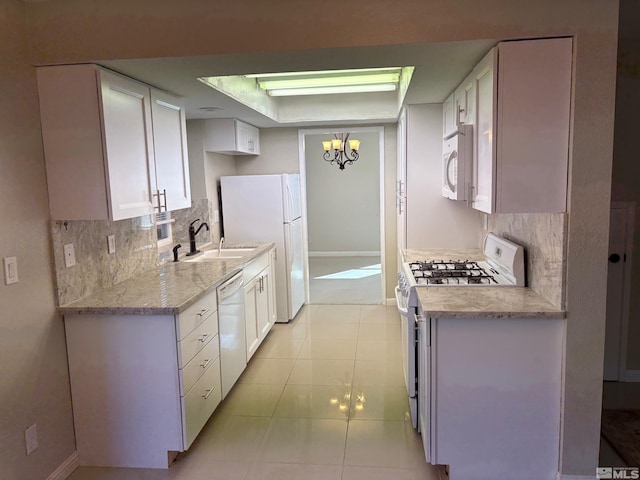 kitchen with a sink, white appliances, tasteful backsplash, and white cabinetry