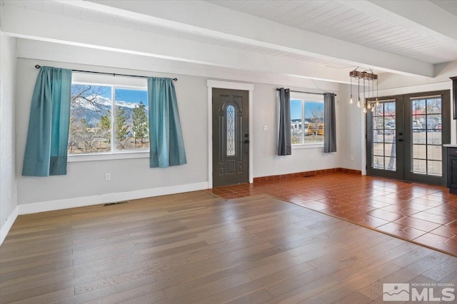 entrance foyer with hardwood / wood-style floors, beam ceiling, french doors, and visible vents