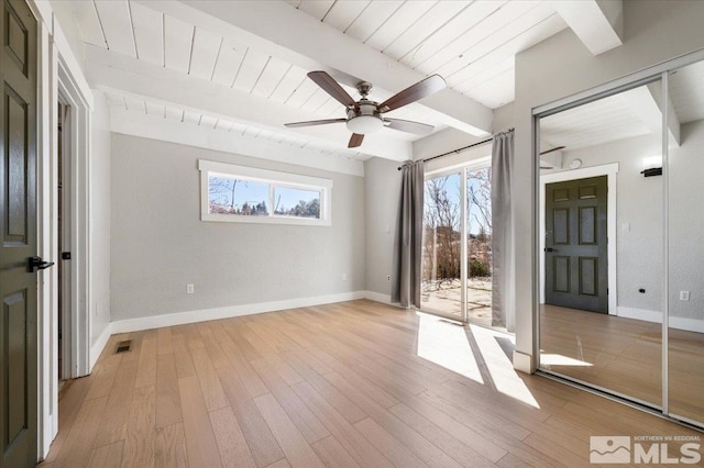 unfurnished room with light wood-type flooring, beamed ceiling, baseboards, and wooden ceiling