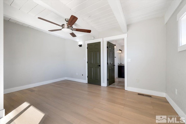 spare room featuring beamed ceiling, visible vents, baseboards, and light wood-style floors