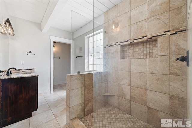 full bath with vanity, beam ceiling, tile patterned flooring, and a tile shower