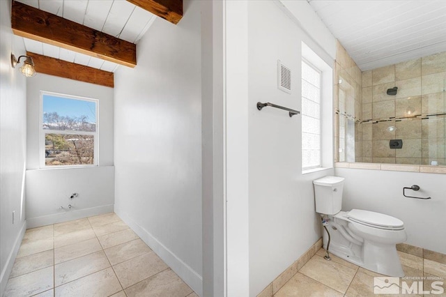 bathroom featuring tile patterned floors, visible vents, beam ceiling, toilet, and a tile shower