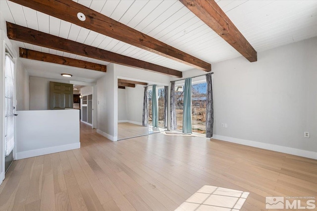 empty room with light wood-style flooring, beamed ceiling, and baseboards