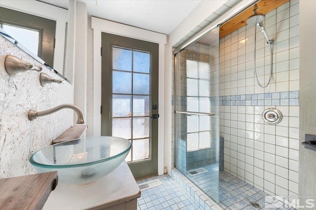 full bathroom featuring tile patterned floors, visible vents, a shower stall, and vanity