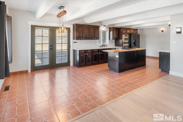 kitchen with visible vents, light countertops, black fridge, french doors, and a sink