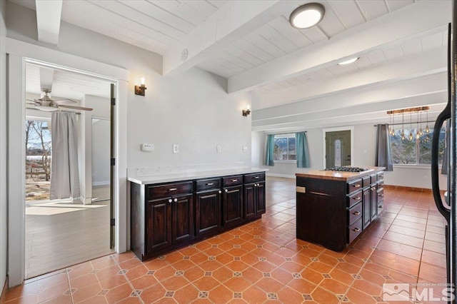 kitchen featuring beamed ceiling, a healthy amount of sunlight, and wooden ceiling