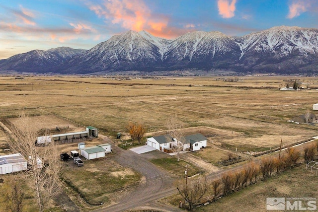 aerial view at dusk featuring a rural view and a mountain view