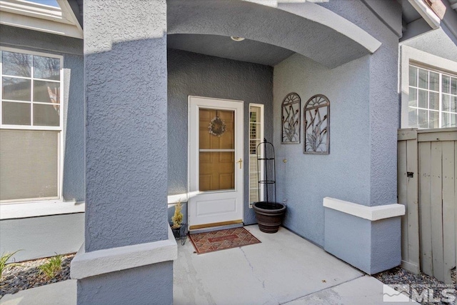 view of exterior entry featuring stucco siding