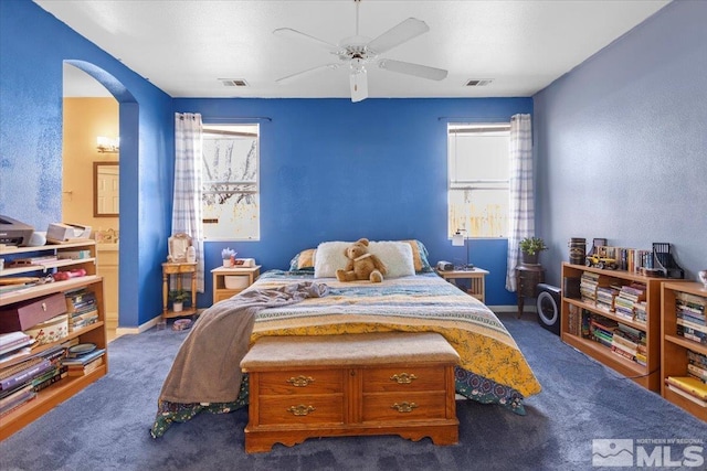 bedroom featuring visible vents, arched walkways, carpet, and ensuite bath