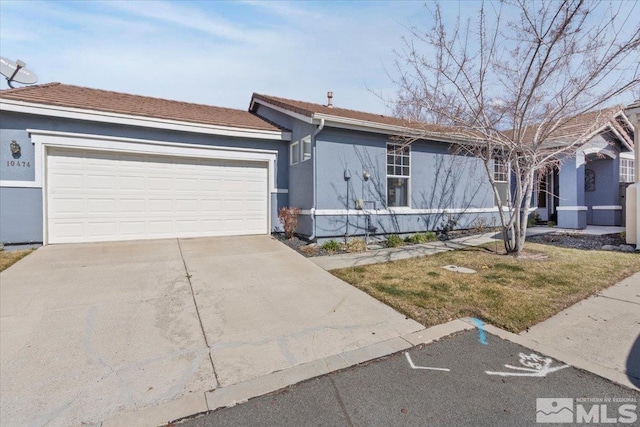 single story home with concrete driveway, an attached garage, and stucco siding