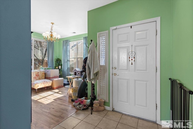 tiled entrance foyer with a notable chandelier and visible vents