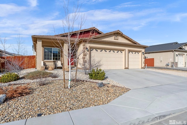 ranch-style house featuring an attached garage, fence, driveway, and stucco siding