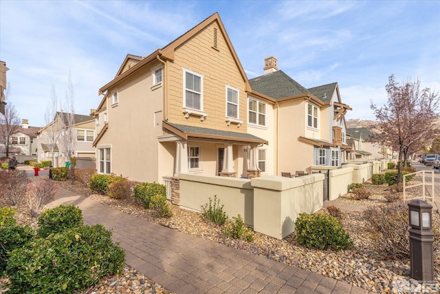 exterior space featuring a fenced front yard, a residential view, and stucco siding