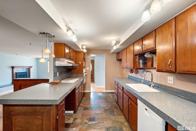 kitchen with a sink, stone finish flooring, white appliances, and brown cabinets