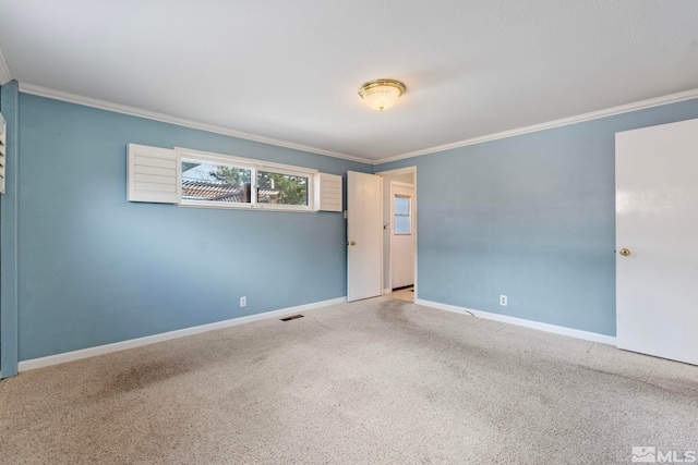 spare room featuring ornamental molding, baseboards, and carpet floors