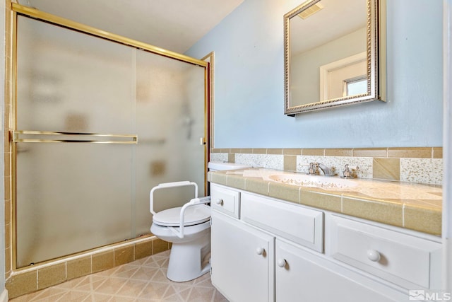 bathroom with vanity, a shower stall, toilet, and visible vents