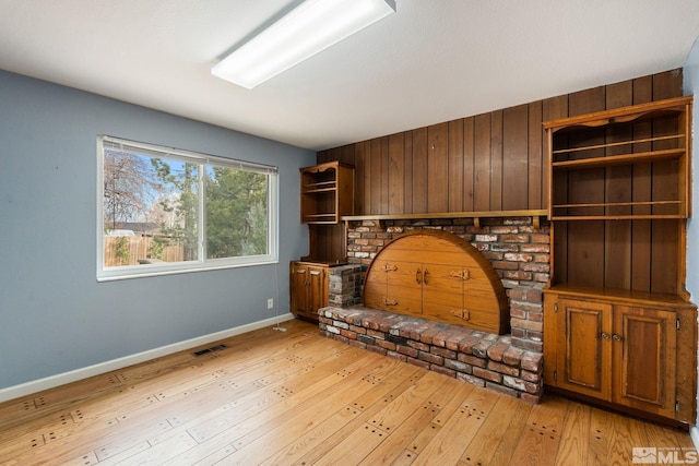 unfurnished living room with visible vents, light wood-style flooring, and baseboards