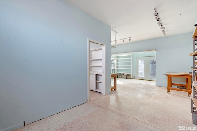 empty room featuring track lighting and french doors