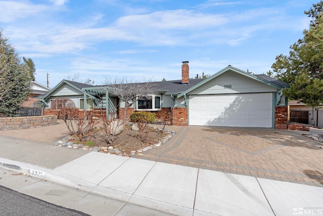 ranch-style home with brick siding, fence, a chimney, decorative driveway, and an attached garage