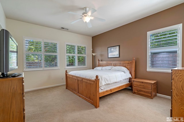 bedroom with a ceiling fan, baseboards, visible vents, and light carpet