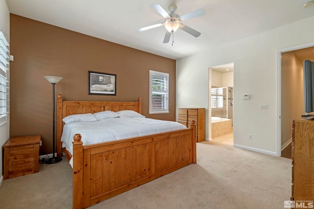 bedroom featuring baseboards, light colored carpet, ceiling fan, and ensuite bathroom