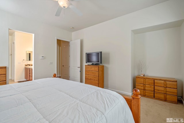 bedroom featuring ceiling fan, ensuite bathroom, and baseboards