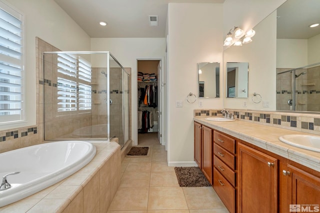 bathroom with visible vents, a sink, a shower stall, a garden tub, and tile patterned floors