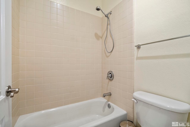 full bathroom featuring toilet, shower / bathing tub combination, and a textured wall